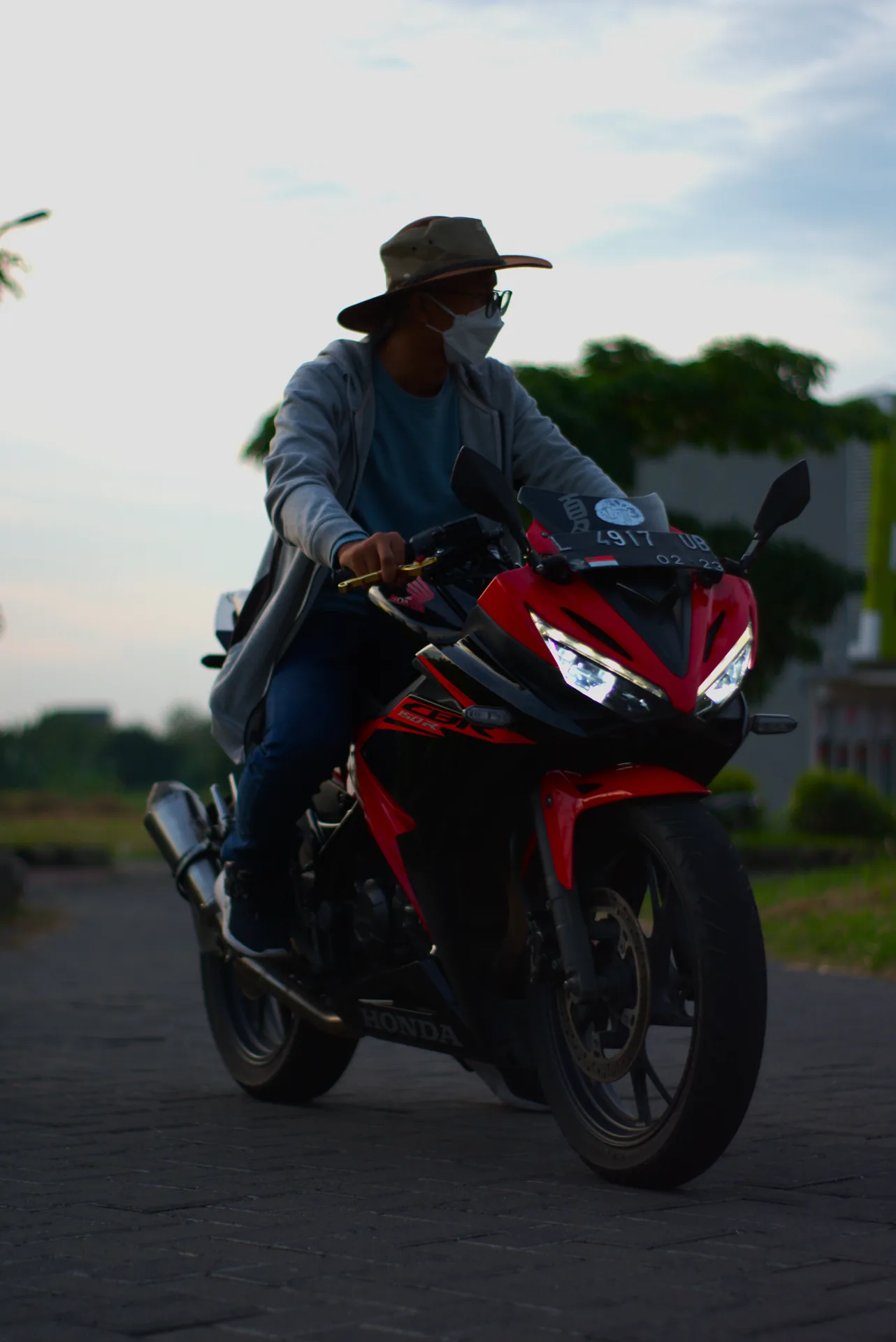 Cinematic street portrait of a rider on a red CBR motorcycle