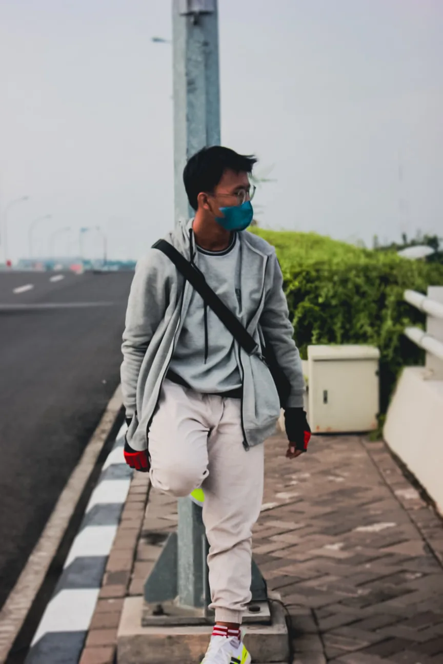 Masked street portrait beside a concrete roadway at GKB Convex