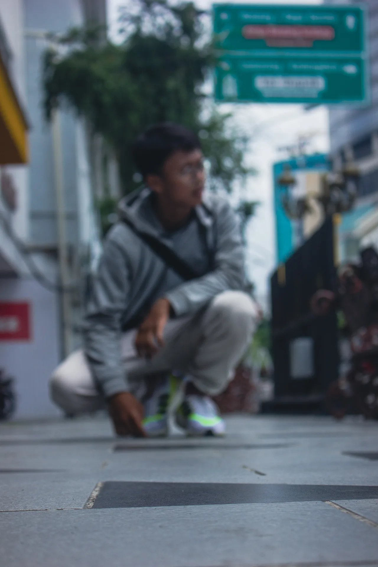 Candid shallow-focus street portrait near direction signs