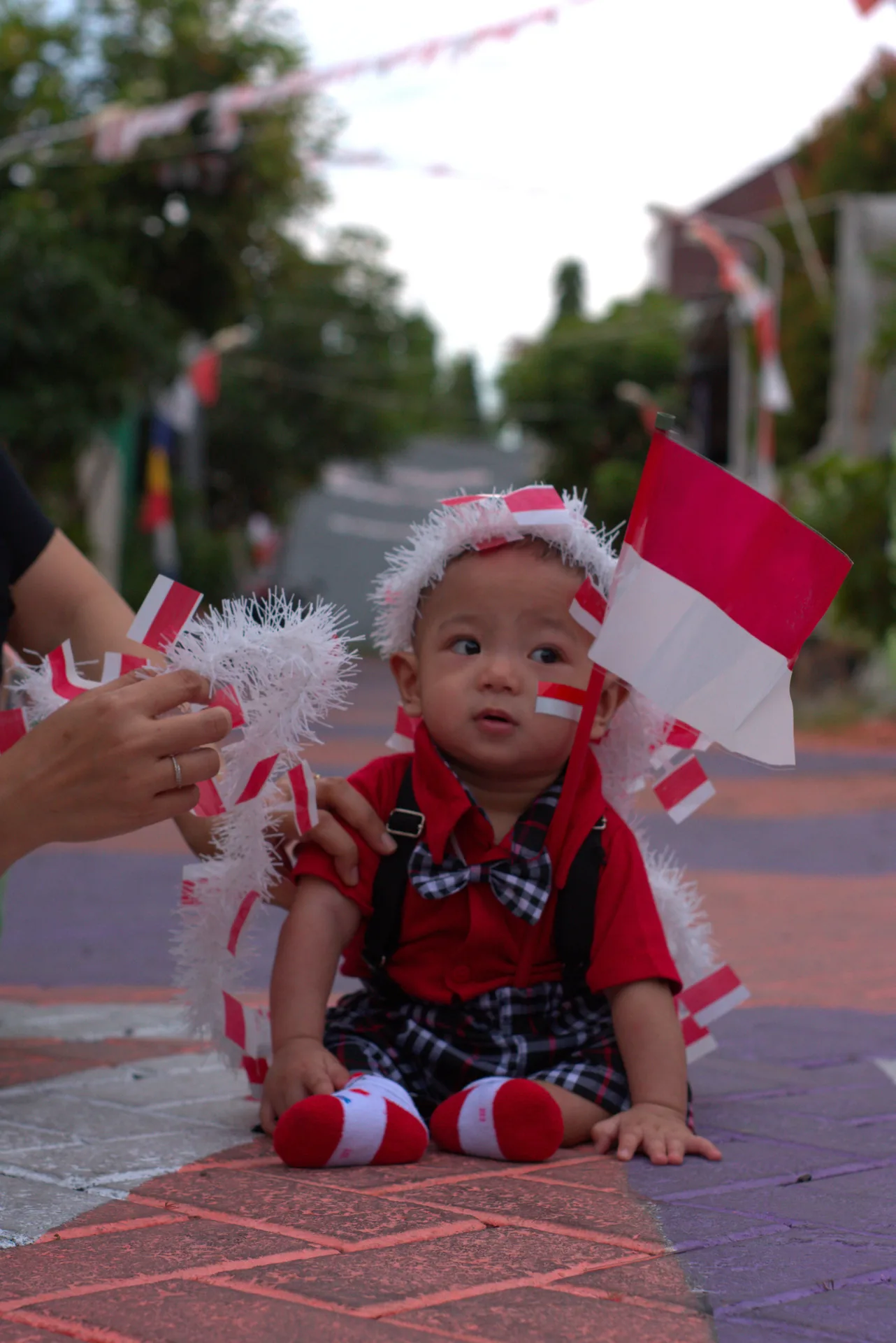 Azel wearing red and holding a small Indonesian flag during the photo hunt