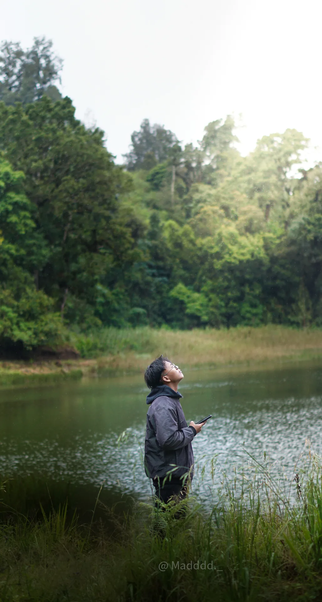 A person standing at the edge of Ranu Regulo and looking across the lake